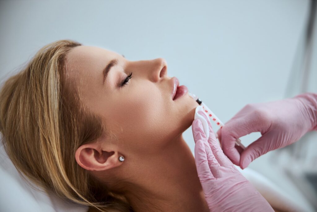 Side view of a woman undergoing a lip augmentation procedure