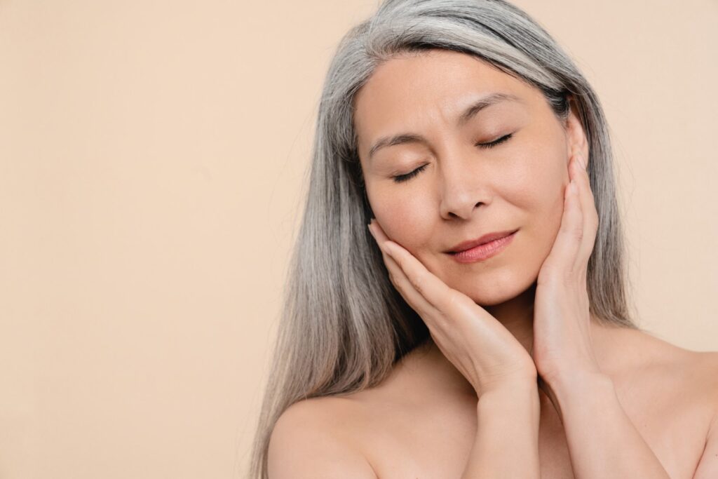 Older woman holding her face and skin after receiving Sculptra injections