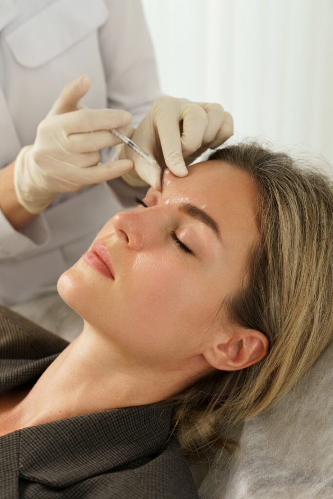 Woman receiving dermal filler injection in eyebrows in Trenton Michigan